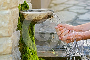 Washing hands in fresh, cold, potable source water on a mountain, Drinking Spring, Wooden Pipe of Fresh Potable, Unpolluted,
