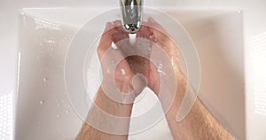 Washing hands in sink with soap to clean skin for good hygiene