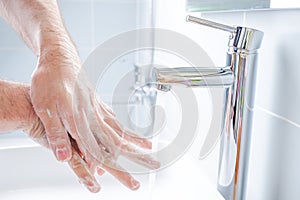 Washing hands with soap in the bathroom