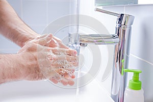 Washing hands with soap in the bathroom