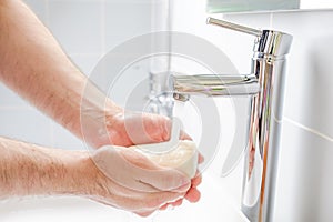 Washing hands with soap in the bathroom