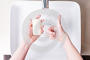 Washing hands with soap in the bathroom