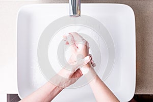 Washing hands with soap in the bathroom