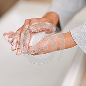 Washing hands, soap foam and cleaning in bathroom for germs, bacteria or viruses as routine. Hygiene, healthcare and