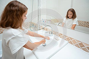 Washing hands with soap under the tap with water. The child washes his hands. The concept of hygiene. Selective focus