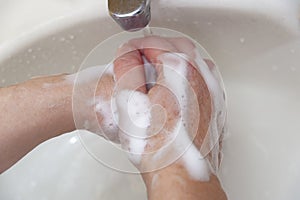 Washing hands with soap and water for protection against Coronavirus COVID-19 and other contagious diseases. Close-up. Top view