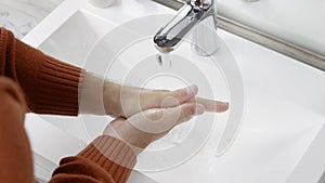 Washing hands with soap and water under the tap,close-upWash hands intensively with a tap with water,a guy,a man washes off the di