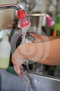 Washing hands under flowing tap water Kitchen porter washing his hands in professional kitchen