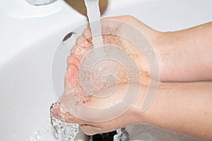 Washing hands under the water tap