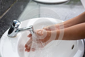 Washing hands in water running