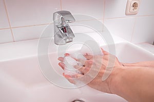 Washing hands with soap to prevent contamination