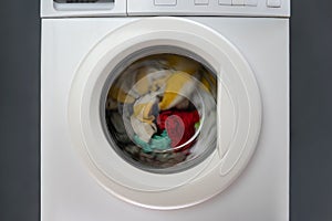 Washing machine with dirty clothes inside. Front view ashing things in washing machine. Rtation drum of washing machine