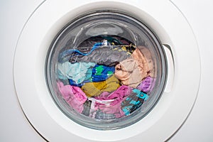 A washing machine with dirty clothes inside. Modern washing machine