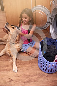 Washing machine, dog and child with laundry in home for cleaning clothes and housekeeping. Happy, hygiene and young girl