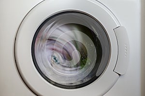 Washing machine door with rotating garments i