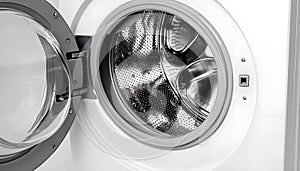 Washing machine with empty drum as background, closeup