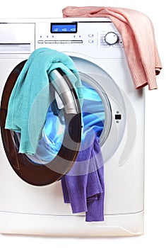 The washing machine with an open door and linen