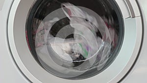 Washing machine working  with rotating garments inside, process of cleaning cloth with washing machine, laundry concept