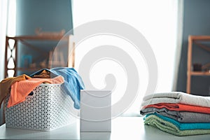 Washing powder standing near folded laundry