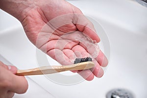 Washing and removing organic residues with a bamboo toothbrush from orthodontic invisible braces