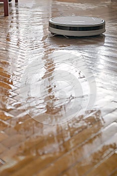 Washing robot vacuum cleaner makes wet cleaning of a parquet floor. Indispensable help in the household.