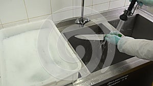 Washing and sanitizing of industrial meat knife.