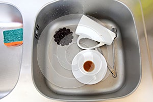 Dishwashing. White dishes in the kitchen sink.