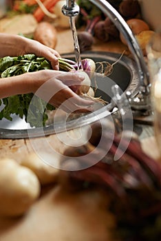 Washing, vegetables and hands in kitchen for healthy food, hygiene and cooking or preparation by sink. Person with water