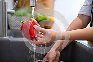 Washing vegetables. A woman in the kitchen