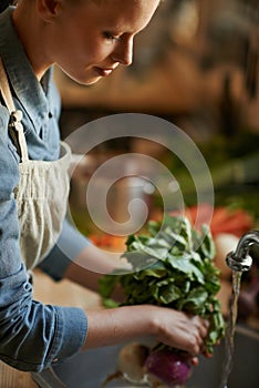 Washing, vegetables and woman in kitchen for healthy food, hygiene and cooking or preparation by sink. Person with water