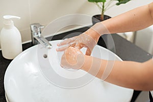 Washing woman fingers hands with soap under crane with water