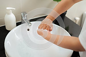 Washing of woman hands with soap under the crane with water