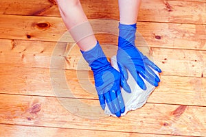 Washing wooden floors with rubber gloves