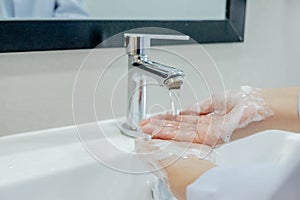 Washing your hands in the sink for cleanliness, rinsing off dirt and preventing the virus