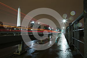 Washington Monument Lit Up at Night in the Rain with Light Trails from Cars