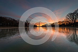 Washington monument reflected in the frozen waters of the lake at sunset