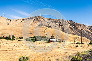 Washington state dry climate area landscape with farm\'s shed and windpower turbines photo