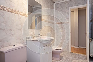 Washroom with pink porcelain fixtures, veined wall tiles, gold valance,