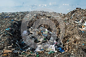 Wastage pit at the garbage dump full of smoke, litter, plastic bottles,rubbish and trash at tropical island