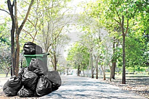 Waste bin green recycle and garbage plastic bags at beside walk way road, many trash plastic bags on street ground floor at park