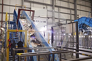 Waste cardboard entering recycling plant on a conveyor belt