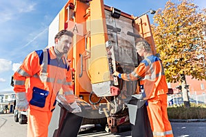 Waste collector gripping handle of garbage truck