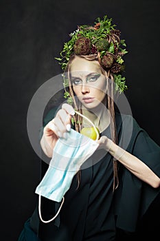 Waste during COVID-19. Nature woman with used single-use face mask. Environmental pollution and environment protection concept