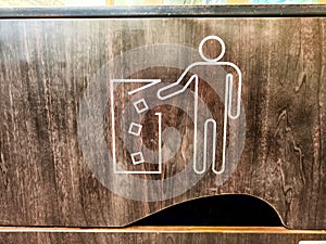Waste Disposal Icon on a Wooden Trash Bin. A graphic of a person disposing of trash
