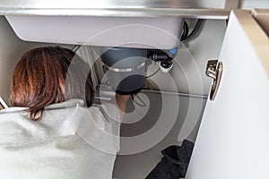 Waste disposal leak under a sink, broken garbage chopper photo