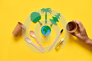 Less waste eco freindly flat lay. Green trees, Earth, wooden cutlery and toothbrush. no plastic