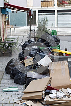 waste and garbage bursting over the sidewalk near urban cafe
