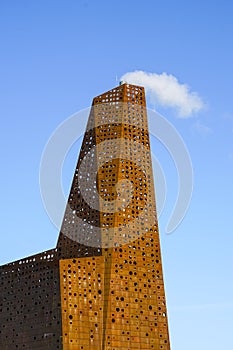 Waste incineration and recycling factory chimney in Roskilde, Denmark on blue sky background.