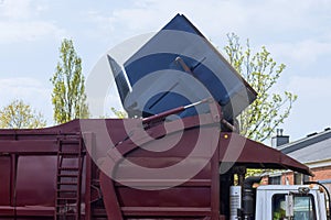 Waste is loaded into trash bin by a municipal sanitation disposal service recycling garbage collector truck