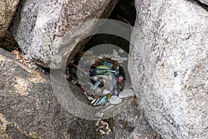 waste paper and plastic caught between rocks